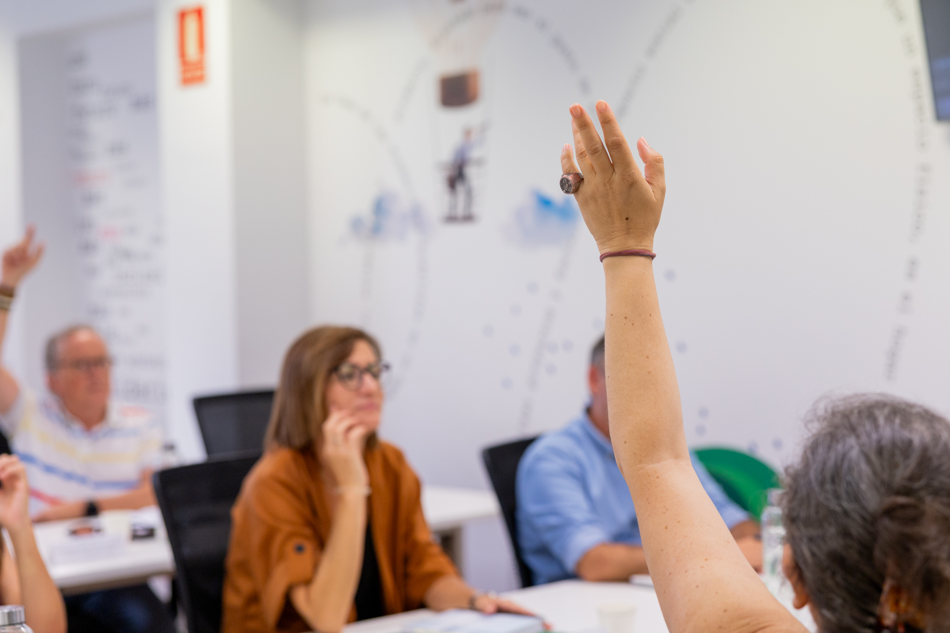Participante levantando la mano durante una formación